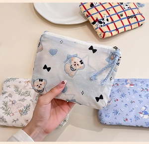 Detailed view of mini cotton zipper pouch showing floral patterns and cute puppy prints