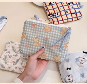 Close-up of assorted mini cotton coin purses with cartoon prints and zipper closures