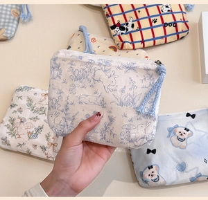 Detailed view of mini canvas pouch with cute dog print, zipper, and wrist strap