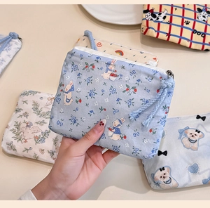 Close-up of cute cartoon mini cotton coin purses with metal zippers and various floral prints