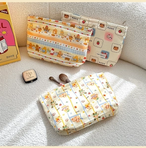 Close-up of canvas makeup bags featuring cute cartoon bear and rabbit patterns