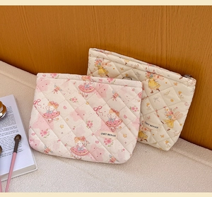 Detailed macro view of quilted cotton cosmetic bags with cute floral and cartoon girl patterns
