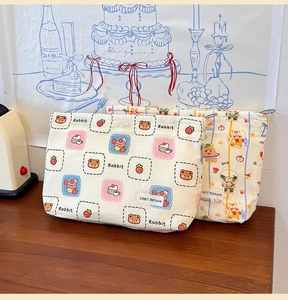 Detail of canvas toiletry bags with cute cartoon prints and secure metal zippers