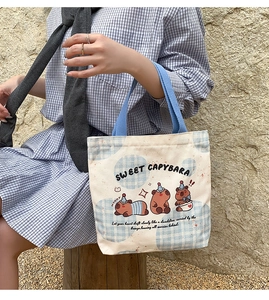 Detail of Capybara canvas tote bag showing the thick fabric texture and blue handles