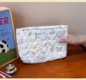Detailed macro of heart-quilted toiletry bag with cute cat patterns and branding