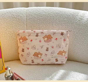 Detail of cute pink cartoon makeup bag with teddy bear prints and woven brand label