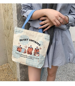 Detail showing high-quality canvas fabric and cute Capybara cartoon print on the handbag