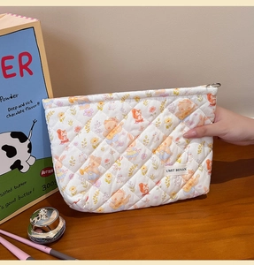 Detail of quilted makeup bag with cute animal patterns and smooth metal zipper closure