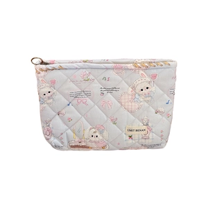 Blue quilted makeup bag with cute rabbit prints and a sturdy zipper closure for travel