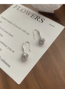 Macro shot of S925 silver cube earrings with round zircon inlay on a display card