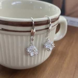 S925 sterling silver geometric cube earrings with zircons on a ceramic cup edge