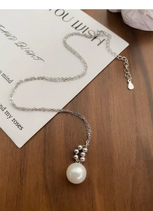 Collier minimaliste en argent S925 avec perle sur fond en bois vintage et carte artistique