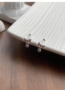 Detail view of S925 sterling silver bow knot earrings with polished round bead drops