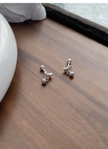 Detail of S999 silver bow earrings with round bead pendant and screw-back ball closure