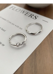 Detail of S925 sterling silver bow and wave rings with adjustable open band design