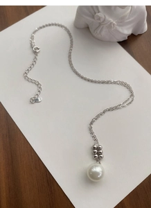 Gros plan du poinçon S925 sur le fermoir du collier en argent avec une perle blanche pure