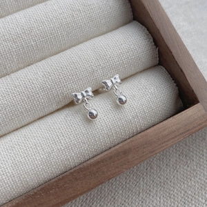 Exquisite S999 sterling silver bow knot stud earrings with round bead pendants on display