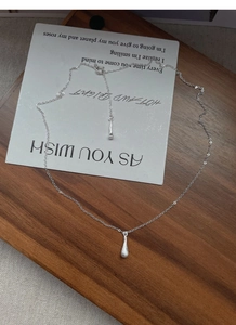 Detail of S925 sterling silver waterdrop pendant necklace with brushed matte finish texture