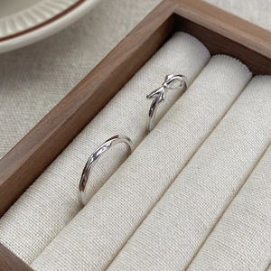 S925 sterling silver bow and twisted band couple rings in a rustic wooden jewelry box