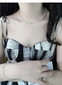 Dettaglio del set collana e bracciale di perle argento S925 con ciondolo dorato