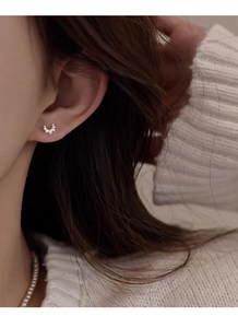 Close-up of S999 sterling silver croissant stud earring with delicate beaded texture