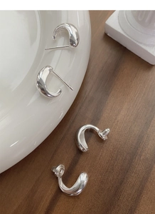 Macro shot of S925 sterling silver U-shaped earrings with polished mirror finish details