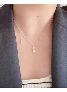 Detail of S925 silver water drop tassel necklace worn with a gray suit and striped shirt