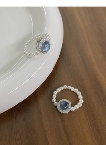 Close-up of S925 silver rings with aquamarine gemstones and round white pearls