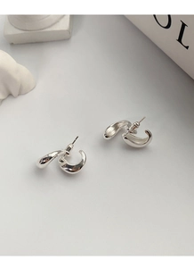 Detailed view of S925 sterling silver liquid metal drop earrings on a grey background