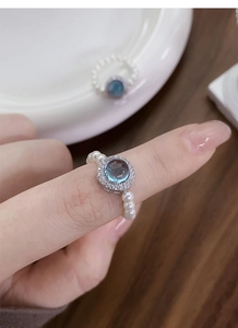 Macro detail of aquamarine blue stone ring with small pearls and zircon accents