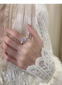 Detailed shot of an S925 silver ring featuring a blue gemstone and elegant pearls