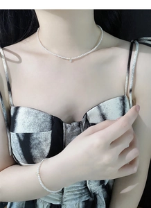 Dettaglio del set collana e bracciale di perle in argento S925 con ciondolo dorato