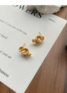 Close-up of matte gold S925 silver ruffled earrings with artistic spiral ribbon design