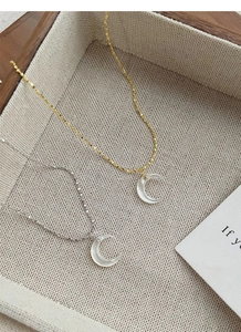 Detail of S925 sterling silver crescent necklaces with mother of pearl and cubic zirconia