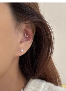 Detail of S999 sterling silver croissant stud earrings and pearl jewelry worn by a model