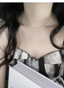 Dettaglio della collana di perle in argento S925 con ciondolo a diamante su una modella