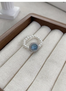 Detail of S925 silver ring featuring blue aquamarine stone and white pearls
