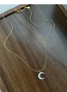 Macro detail of gold S925 silver moon pendant with white mother of pearl and zircon inlay