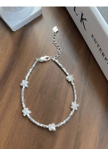 Detail of S925 sterling silver butterfly charm bracelet with textured beads and heart tag