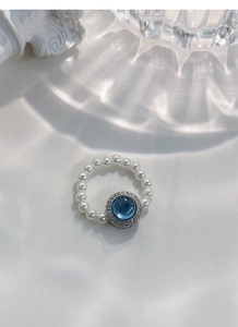 Detail of S925 silver ring featuring blue aquamarine and white pearls in macro view