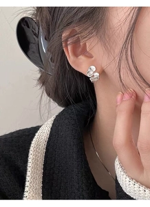 Detailed view of silver irregular ruffle stud earrings with matte liquid metal texture