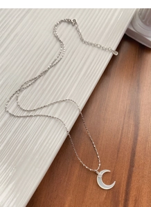 Macro detail of S925 silver crescent moon necklace with white mother of pearl inlay