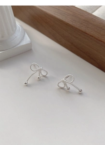 Detail of S925 sterling silver bow knot earrings with twisted texture and metallic beads