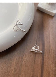 Macro detail of S925 sterling silver bow earrings with twisted wire and polished beads