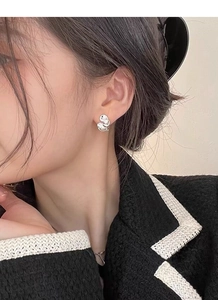 Close-up of elegant S925 silver ruffled edge stud earrings worn by a female model
