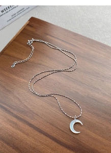 Detailed view of S925 silver crescent moon necklace with iridescent mother of pearl
