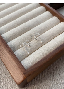 Close-up of S925 sterling silver bow knot stud earrings on a jewelry display box