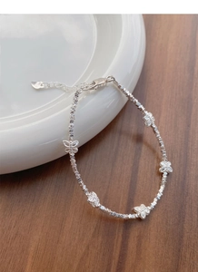 Macro detail of S925 sterling silver butterfly beaded bracelet with irregular facets