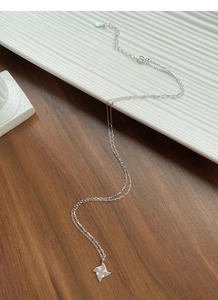 Detail of S925 sterling silver windmill necklace on a ceramic tray with extension chain