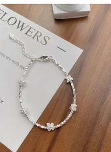 Detail of silver S925 butterfly bracelet with fine beads and lobster clasp on a card